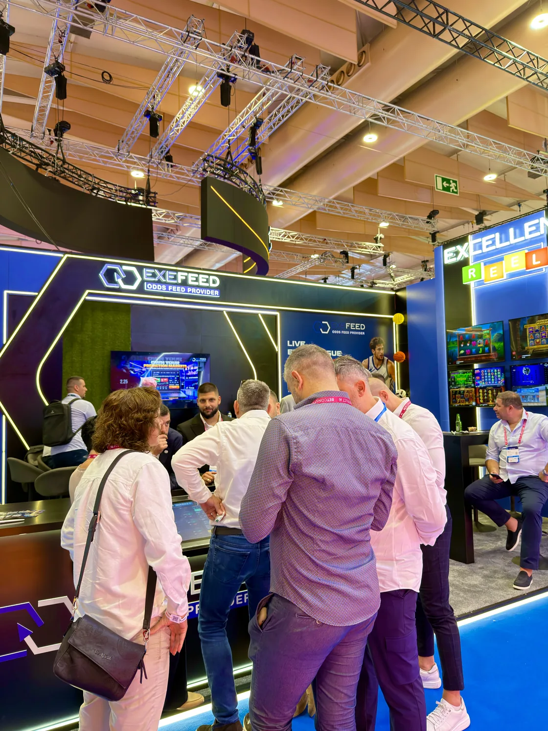 A group gathered in front of the game screens