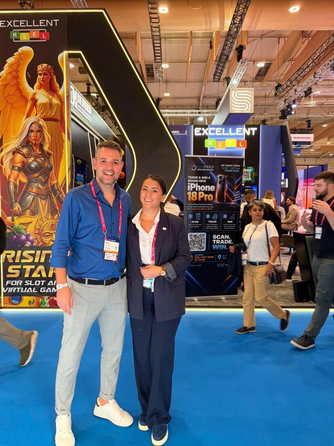Two people photographed in front of the Rising Star display column